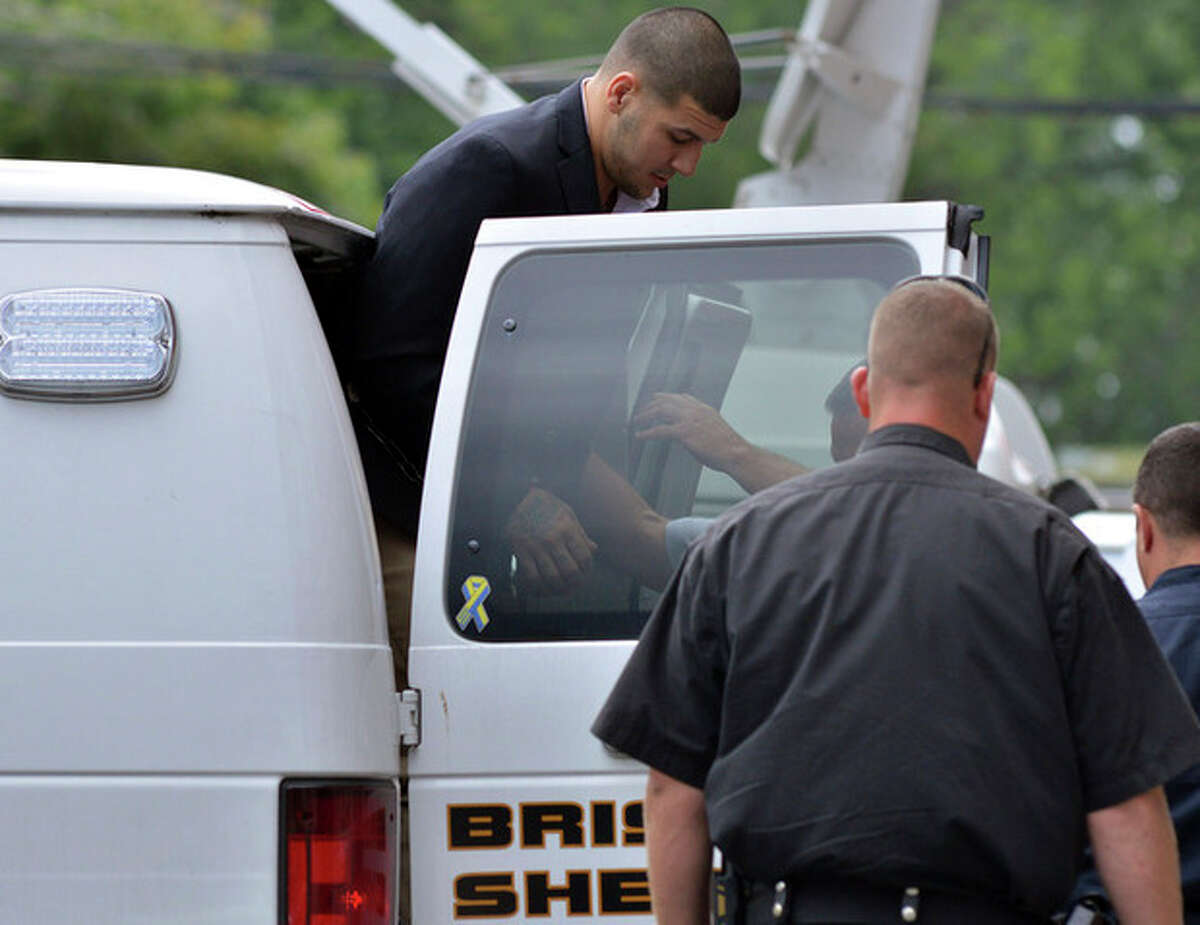 Former New England Patriot football player Aaron Hernandez, is lead from a sheriff's van into a courthouse in Attleboro, Mass., Thursday, Aug. 22, 2013. Hernandez was indicted on first-degree murder and weapons charges in the death of a friend whose bullet-riddled body was found in an industrial park about a mile from the ex-player's home. (AP Photo/Josh Reynolds)