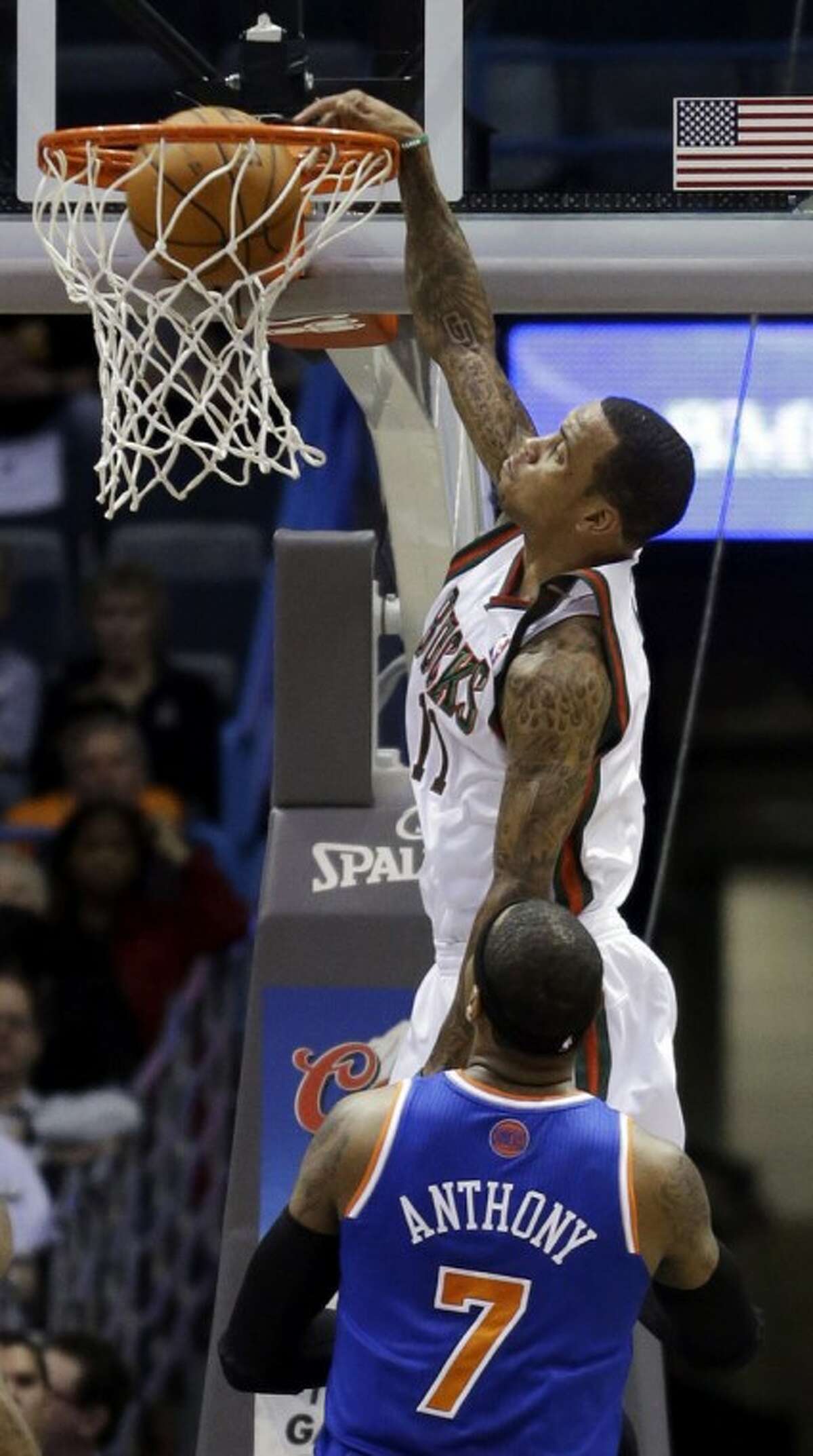 New York Knicks' Carmelo Anthony (7) watches as Milwaukee Bucks' Monta Ellis (11) dunks during the first half of an NBA basketball game Wednesday, Nov. 28, 2012, in Milwaukee. (AP Photo/Morry Gash)