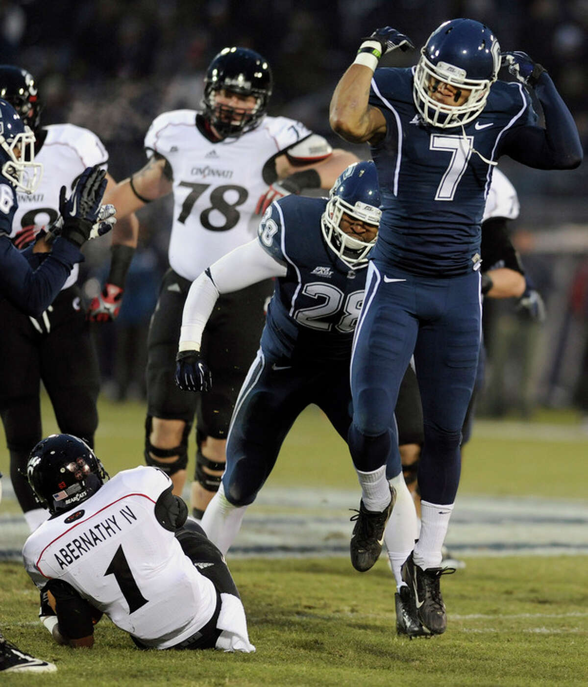 Connecticut cornerback Dwayne Gratz (7), right, reacts after tackling Cincinnati running back Ralph Abernathy (1), left, during the first half of an NCAA college football game at Rentschler Field in East Hartford, Conn., Saturday, Dec. 1, 2012. (AP Photo/Jessica Hill)