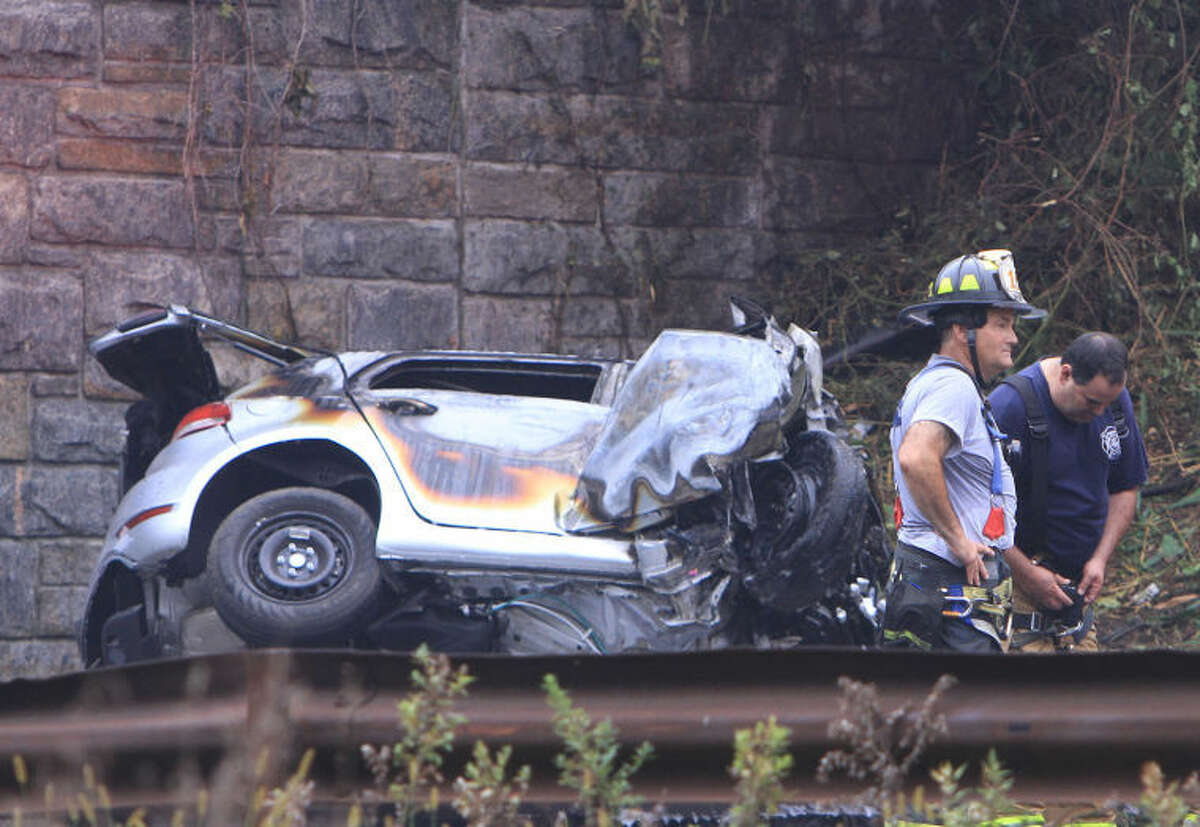Police and firefighters work at the scene of a multi-fatal accident on the northbound Sprain Brook Parkway in Greenbugh, N.Y. on Sunday, Sept. 1, 2013. Police said the car hit the Underhill Road Bridge and burst into flames killing all four occupants early Sunday morning. (AP Photo/The Journal News, Frank Becerra Jr.)
