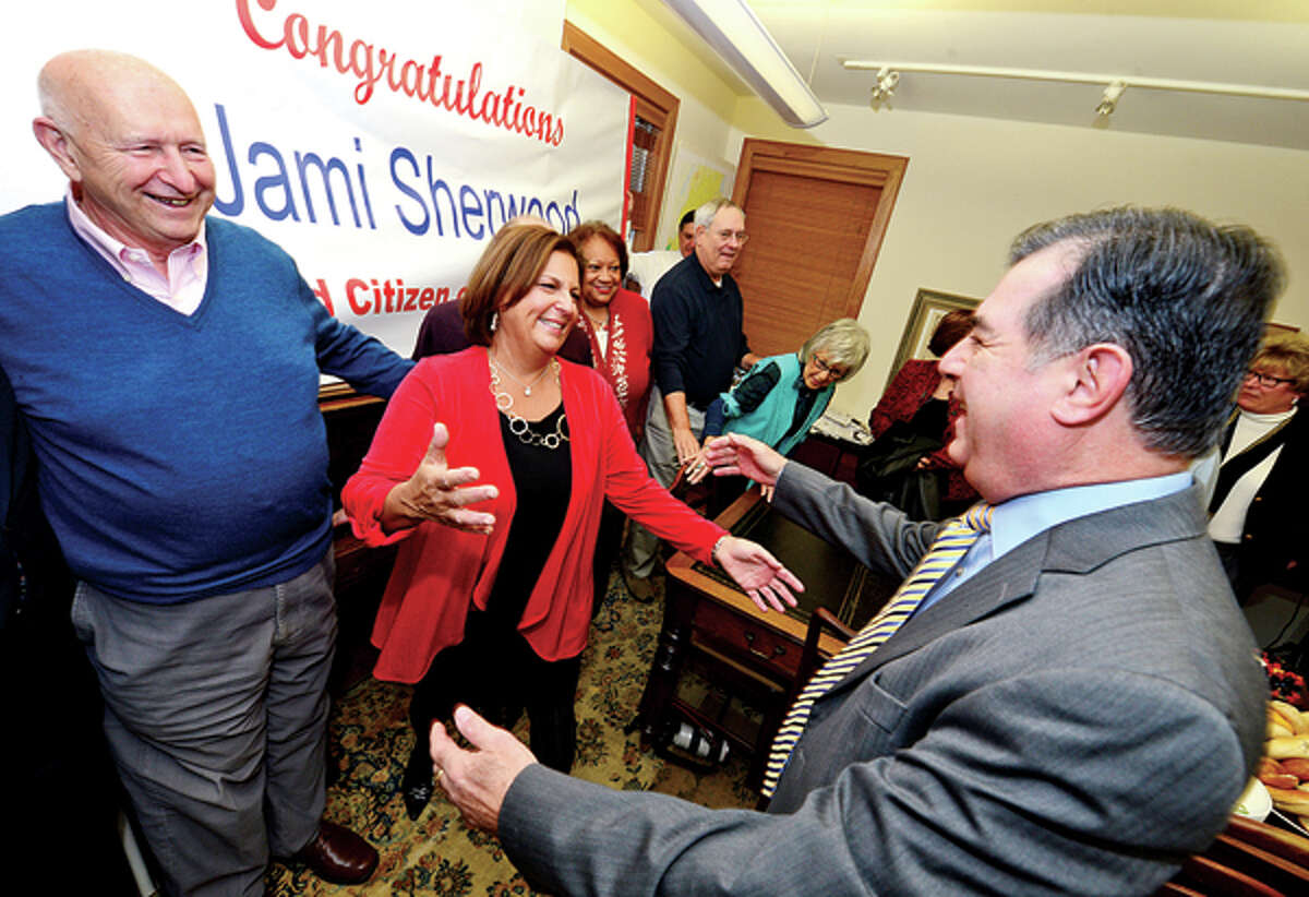 Jami Sherwood is surprised with being named City of Stamford Citizen of the Year as she is greetd by Stamford Mayor Michael Pavia and past Citizen of the Year Al Sanseverino during a morning reception at Redniss and Mead Thursday. Hour photo / Erik Trautmann