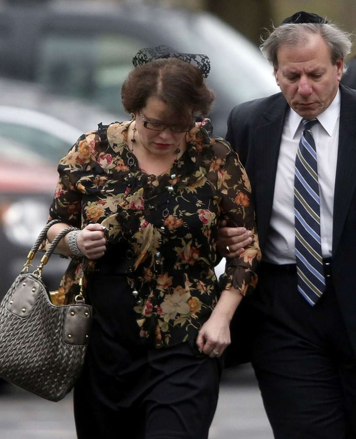 Veronique Pozner is escorted to her car after a funeral service for her 6-year-old son Noah Pozner, Monday, Dec. 17, 2012, in Fairfield, Conn. Noah Pozner was killed when gunman Adam Lanza walked into Sandy Hook Elementary School in Newtown Friday and opened fire, killing 26 people, including 20 children, before killing himself. (AP Photo/Jason DeCrow)