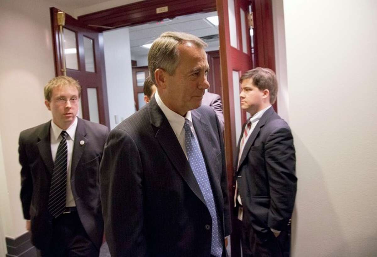 Speaker John Boehner of Ohio, center, departs after a House Republicans meeting on Capitol Hill, Thursday, Dec. 20, 2012 in Washington. Confronted with a revolt among the rank and file, House Republicans abruptly put off a vote Thursday night on legislation allowing tax rates to rise for households earning $1 million and up.(AP Photo/Alex Brandon)