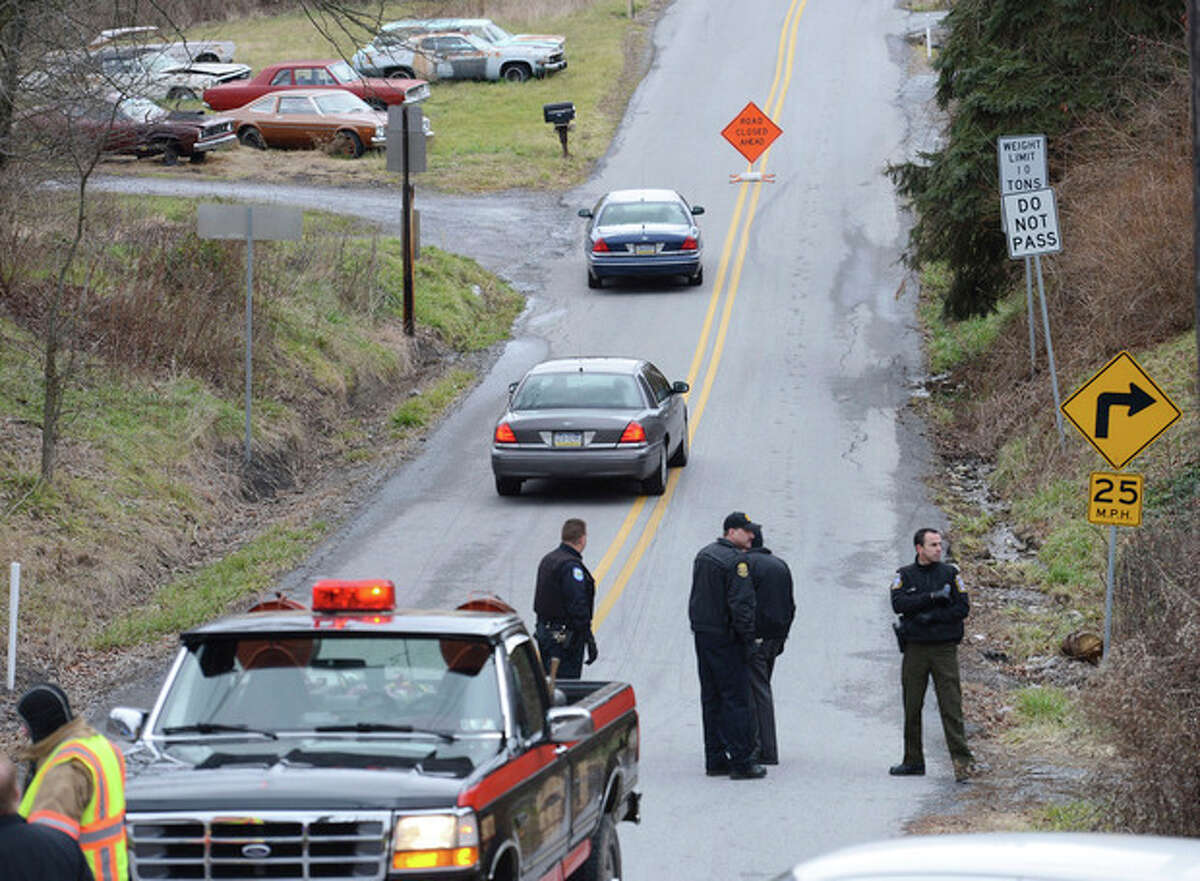 Local law enforcement block off road along Rt. 22 near the Canoe Creek State Park, Pa. while investigating a shooting on Friday, Dec. 21, 2012. The suspect fired at troopers responding to Friday morning's shootings in Frankstown Township, about 70 miles west of Harrisburg. The fleeing gunman then crashed head-on into a trooper's car and got out of his truck and shot again at police, who returned fire and killed him. Blair County District Rich Consiglio says the gunman killed two men and one woman. (AP Photo/Altoona Mirror, J.D. Cavrich)