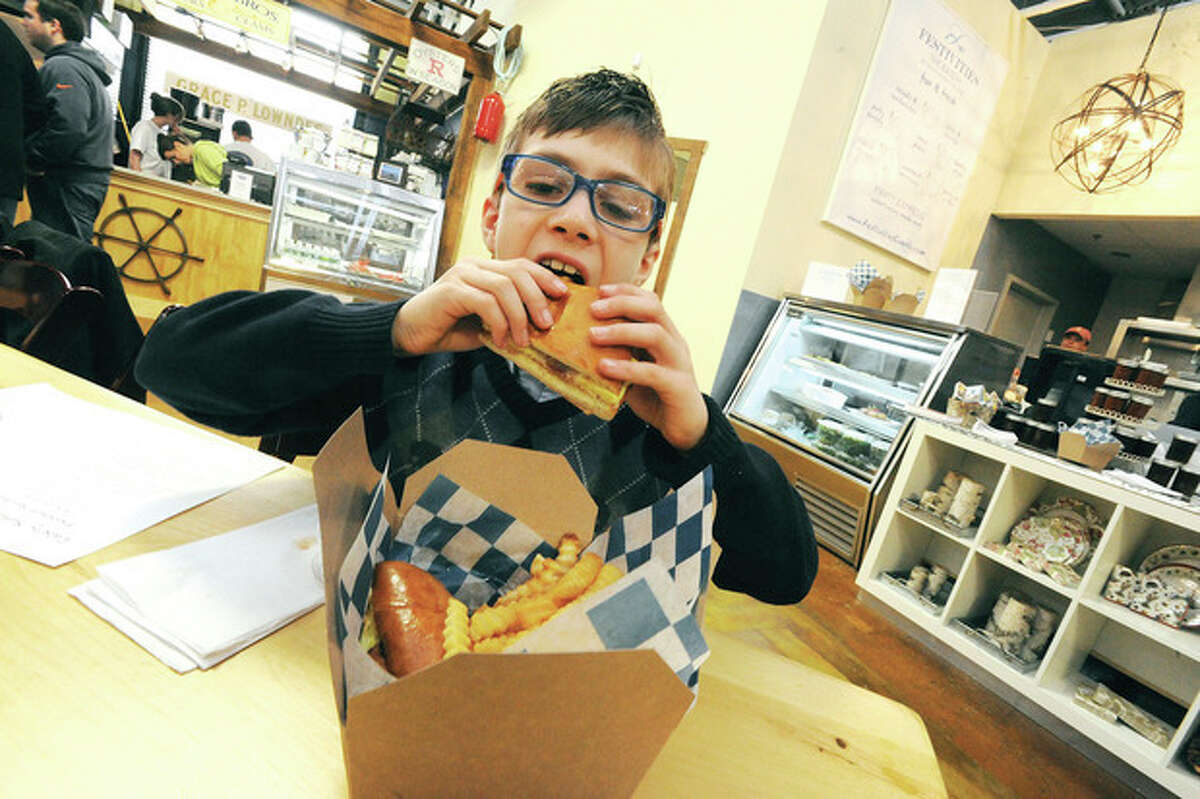 Hour photos / Matthew Vinci Alex D'Adamo, 9, sinks his teeth into a bacon, egg and cheese sandwich at Festivities eatery in the SoNo Marketplace on Sunday. Alex has his own food blog and writes reviews on his restaurant experiences.