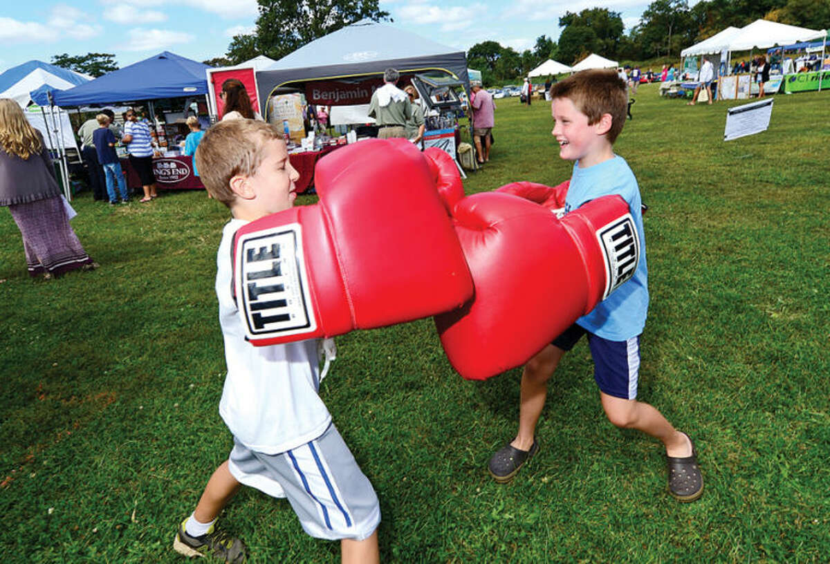 Garrett Volz and Jack Murray, both 8, try the Giant Boxing Gloves from Title Boxing Club during the Live Green Connecticut! green-living and family festival Saturday at Taylor Farm Park. The two-day festival promotes living green with a focus on education, sustainability, caring for the environment and our natural resources.Hour photo / Erik Trautmann