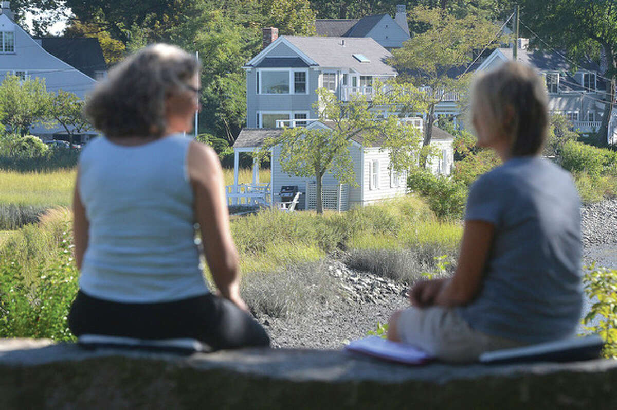 Hour Photo/Alex von Kleydorff Visitors sit on a stone bench at Farm Creek Nature Preserve that looks over the property at 2 Nearwater Road.