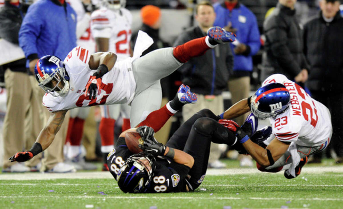 Baltimore Ravens tight end Dennis Pitta, center, makes a catch between New York Giants strong safety Stevie Brown, left, and cornerback Corey Webster in the second half of an NFL football game in Baltimore, Sunday, Dec. 23, 2012. (AP Photo/Nick Wass)