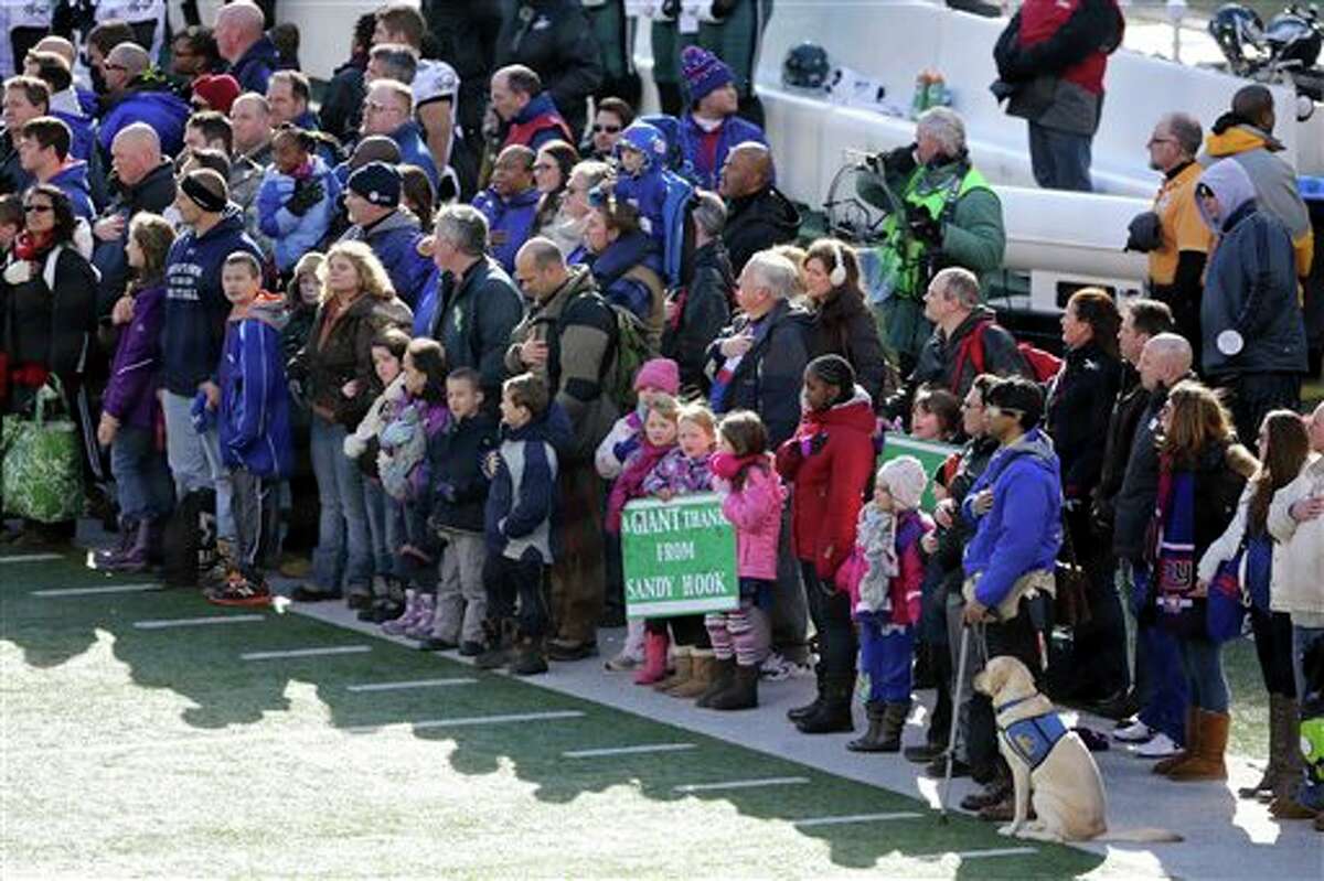A contingent of teachers, parents, and students from Sandy Hook Elementary School in Newtown, Conn., take part in ceremonies before Sunday's game between the New York Giants and the Philadelphia Eagles at MetLife Stadium, Sunday, Dec. 30, 2012, in East Rutherford, N.J. The school was the site of a mass shooting on Dec. 14. (AP Photo/Peter Morgan)