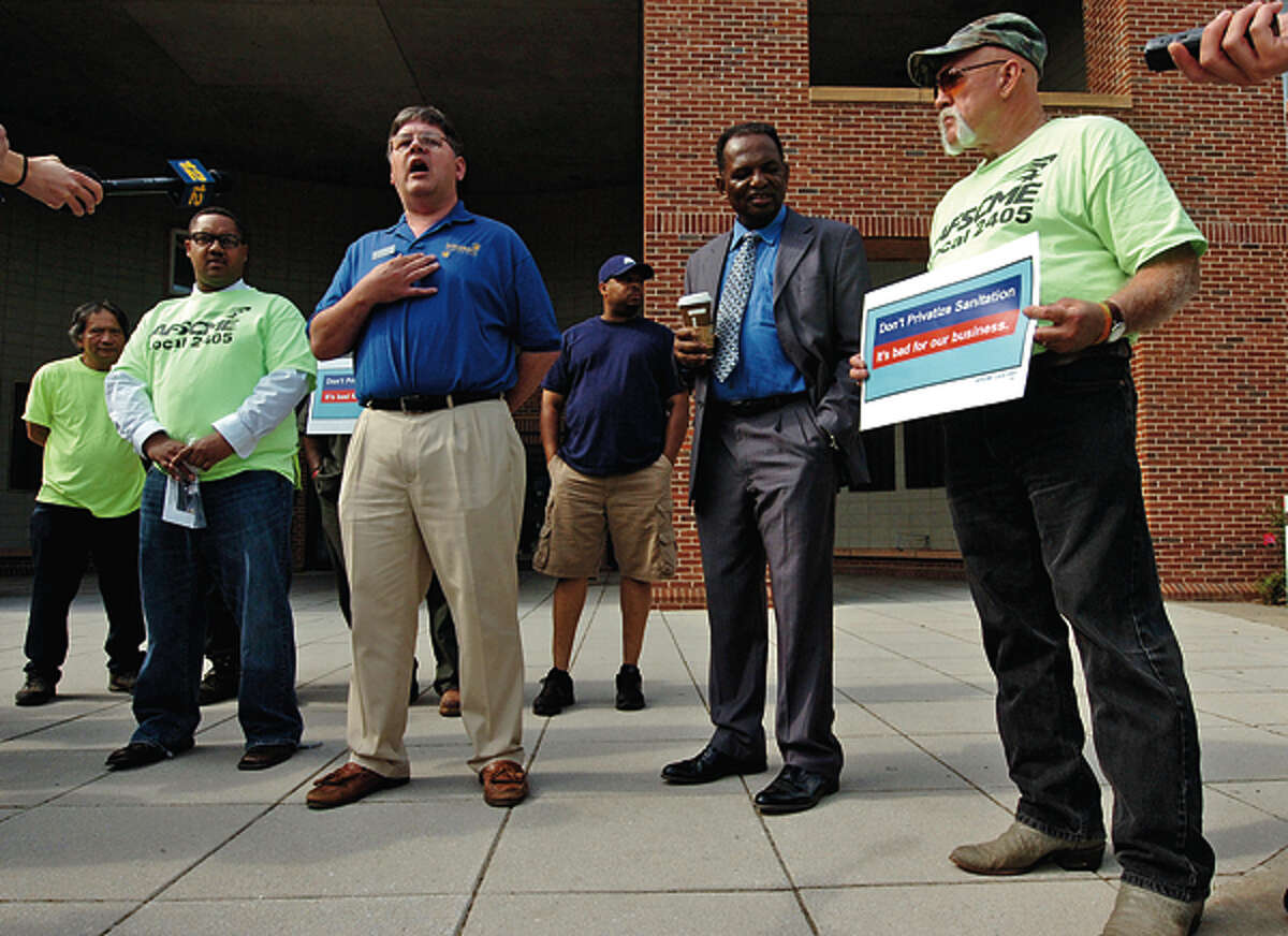 Common Coucilman Matt Miklave and AFSME Local 2405 members who object to garbage privatization speak to the press while protesting outside City Hall. Hour photo / Erik Trautmann
