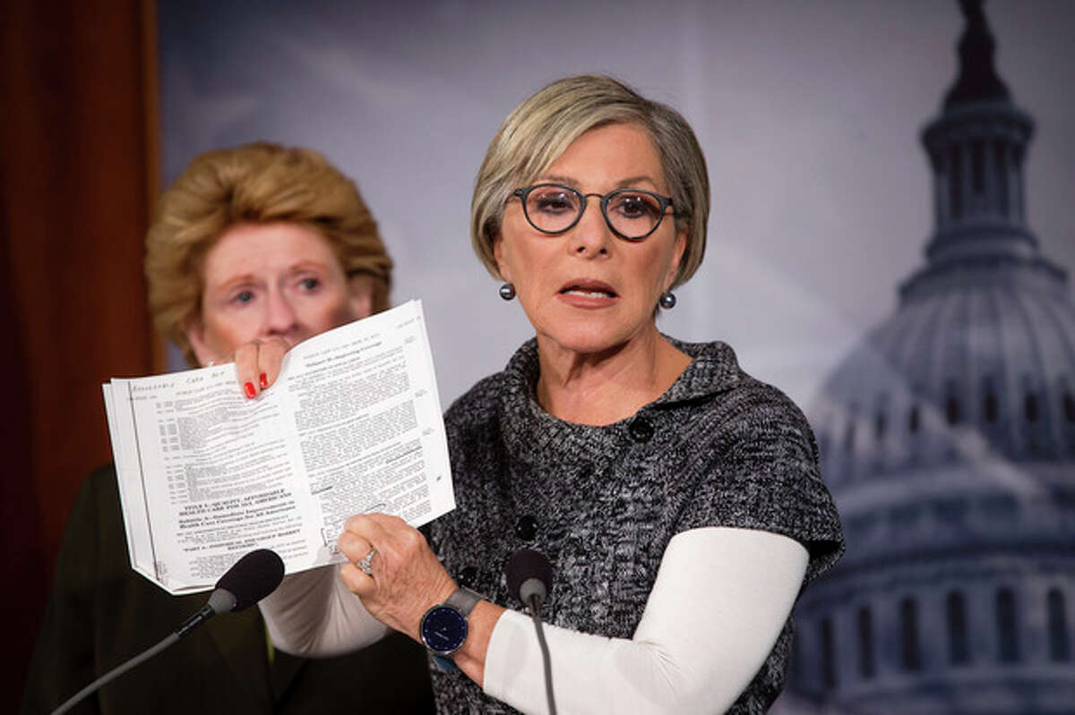Sen. Barbara Boxer, D-Calif., right, holds up a passage from the Affordable Care Act concerning health care benefits for women as she tell reporters that House Republicans' fight against it is tantamount to a war against women, Monday, Sept. 30, 2013, during a news conference on Capitol Hill in Washington. The Senate has the next move on must-do legislation required to keep the government open, and the Democratic-led chamber is expected to reject the latest effort from House Republicans to use a normally routine measure to attack President Barack Obama's signature health care law. Sen. Debbie Stabenow, D-Mich, listens at left. (AP Photo/J. Scott Applewhite)