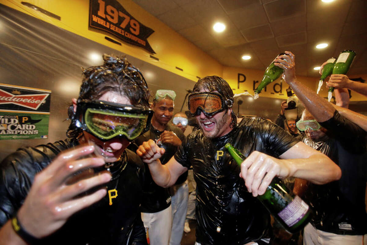Pittsburgh Pirates' Jason Grilli, center, celebrates with Jeff Locke, left, after the Pirates defeated the Cincinnati Reds 6-2 in the NL wild-card playoff baseball game in Pittsburgh on Tuesday, Oct. 1, 2013. The Pirates advanced to the NL division series against the St. Louis Cardinals. (AP Photo/Gene J. Puskar)