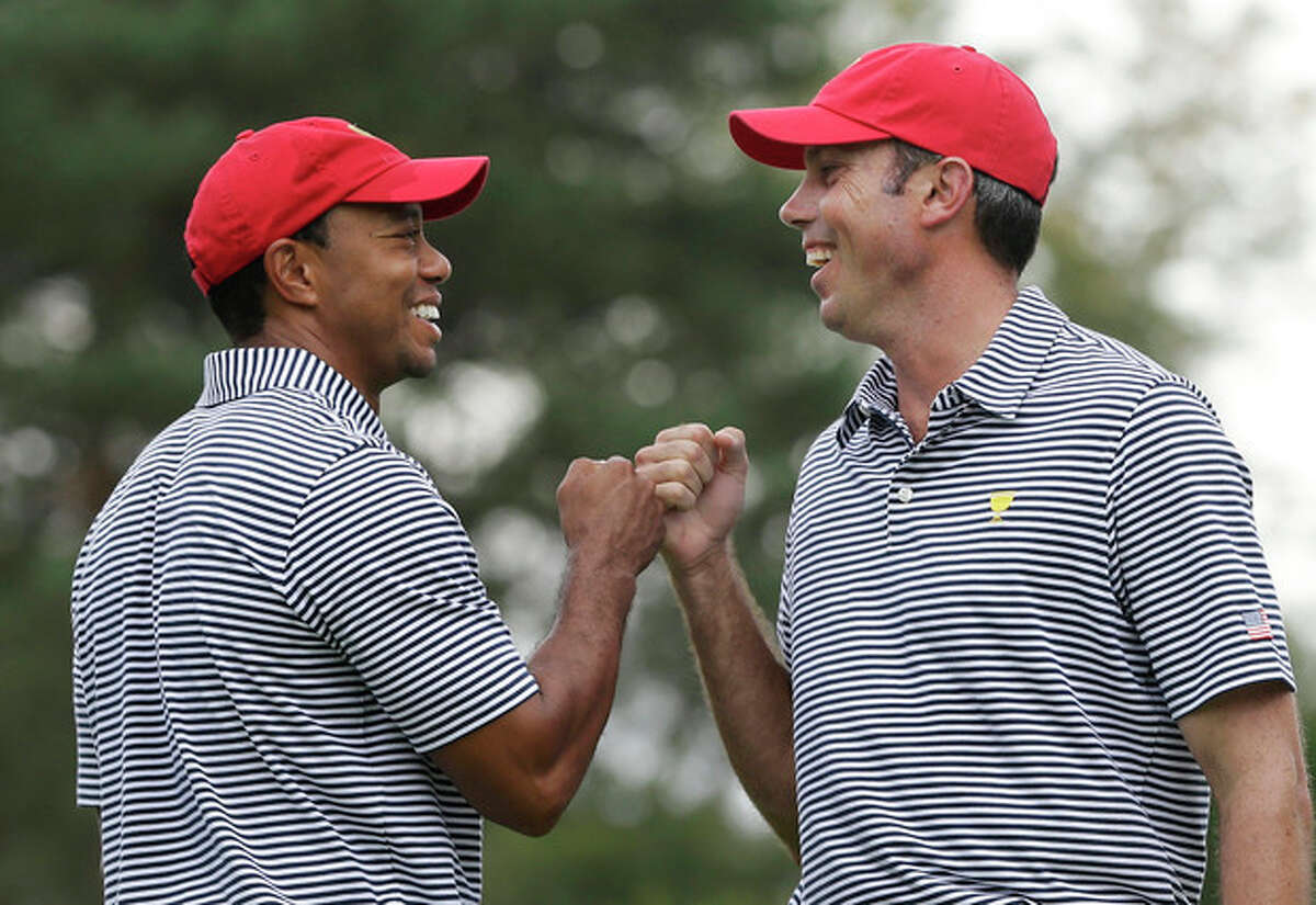 United States team player Tiger Woods, left, and team player Matt Kuchar fist bump after Kuchar made a birdie putt on the fourth hole during a foursome match at the Presidents Cup golf tournament at Muirfield Village Golf Club, Friday, Oct. 4, 2013, in Dublin, Ohio. (AP Photo/Darron Cummings)