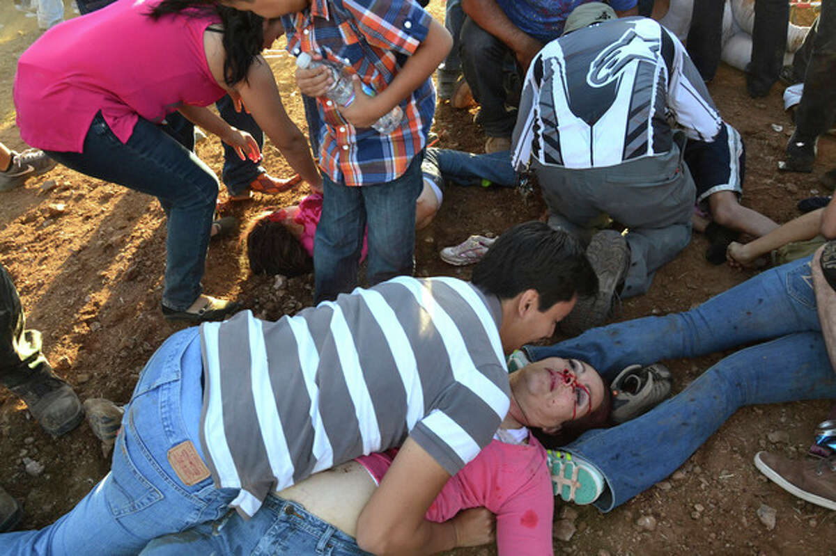 Injured people are treated after an out of control monster truck plowed through a crowd of spectators at a Mexican air show in the city of Chihuahua, Mexico, Saturday Oct. 5, 2013. According to authorities, at least 8 people were killed and 80 were injured. (AP Photo/El Diario de Chihuahua)