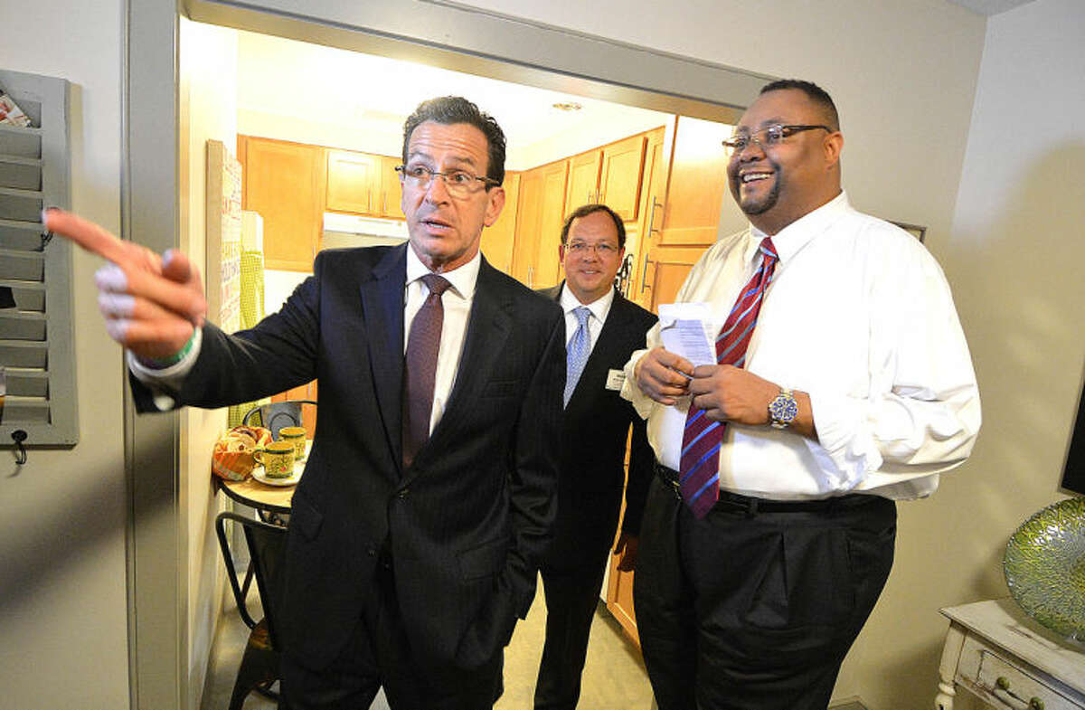 Hour Photo/Alex von Kleydorff . Alan Mathis, President and CEO Liberation Programs Inc along with Mike Matteo of United Health Group show a finished unit at Gini's House to Gov. Dan Malloy