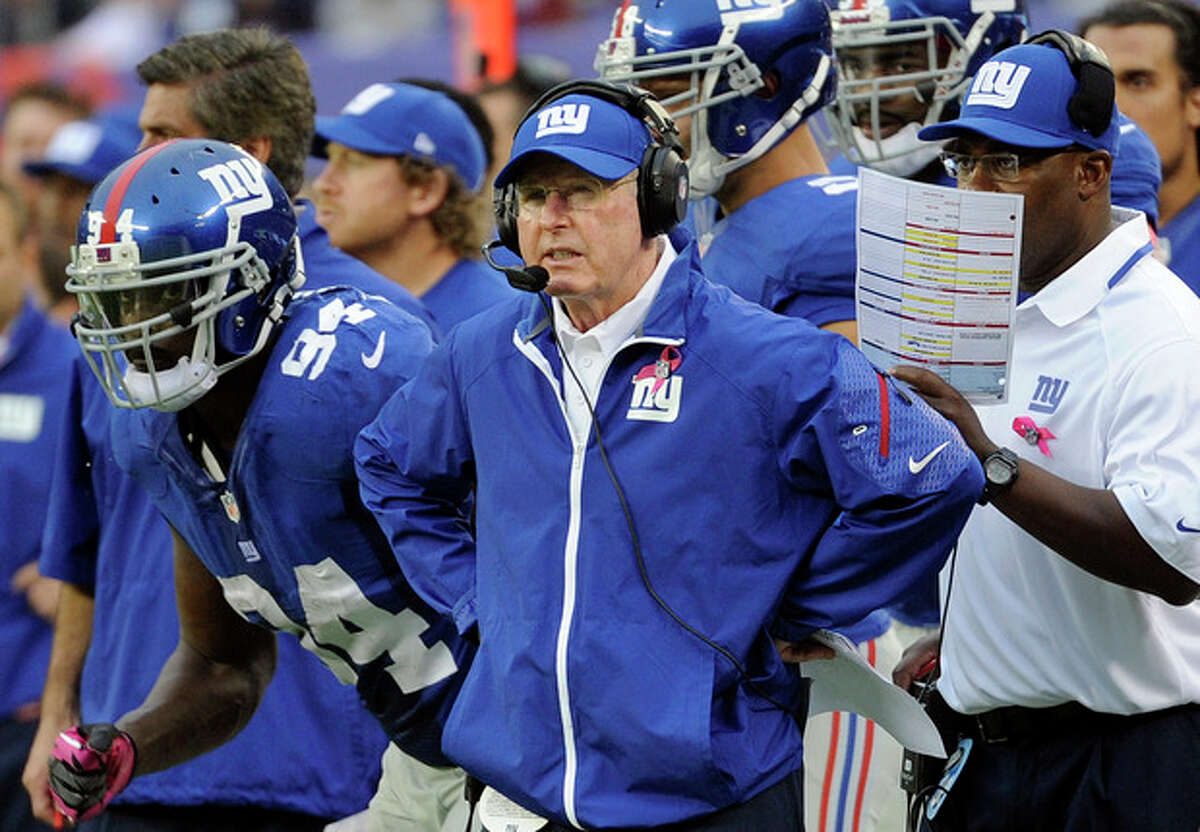 New York Giants head coach Tom Coughlin, center, watches his team play during the first half of an NFL football game against the Philadelphia Eagles, Sunday, Oct. 6, 2013, in East Rutherford, N.J. (AP Photo/Bill Kostroun)