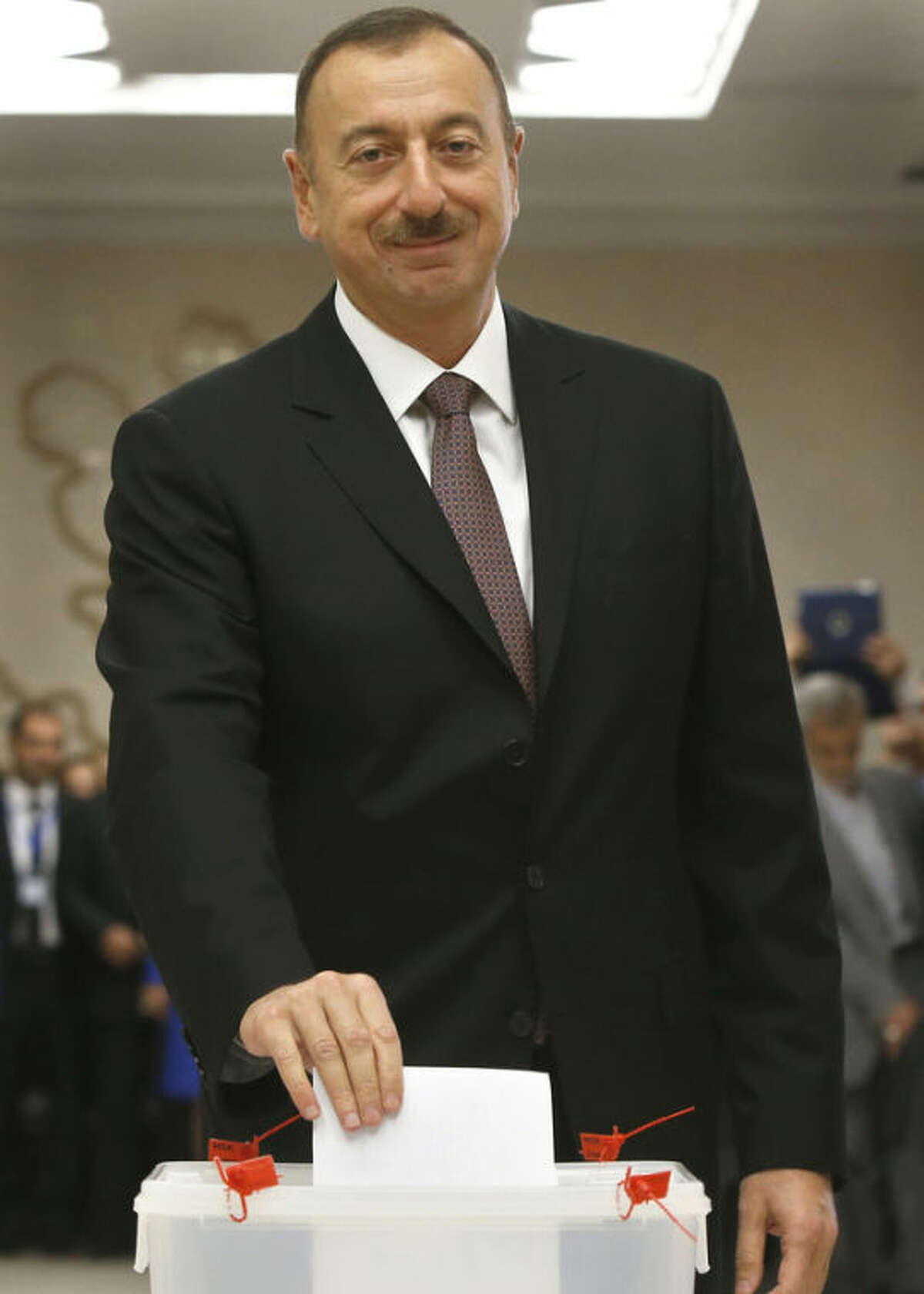 Azerbaijan President Ilham Aliyev casts his ballot paper during the voting at a polling station in Baku, Azerbaijan, Wednesday, Oct. 9, 2013. Presidential election begins in the oil-rich Caspian nation. (AP Photo/Sergei Grits)