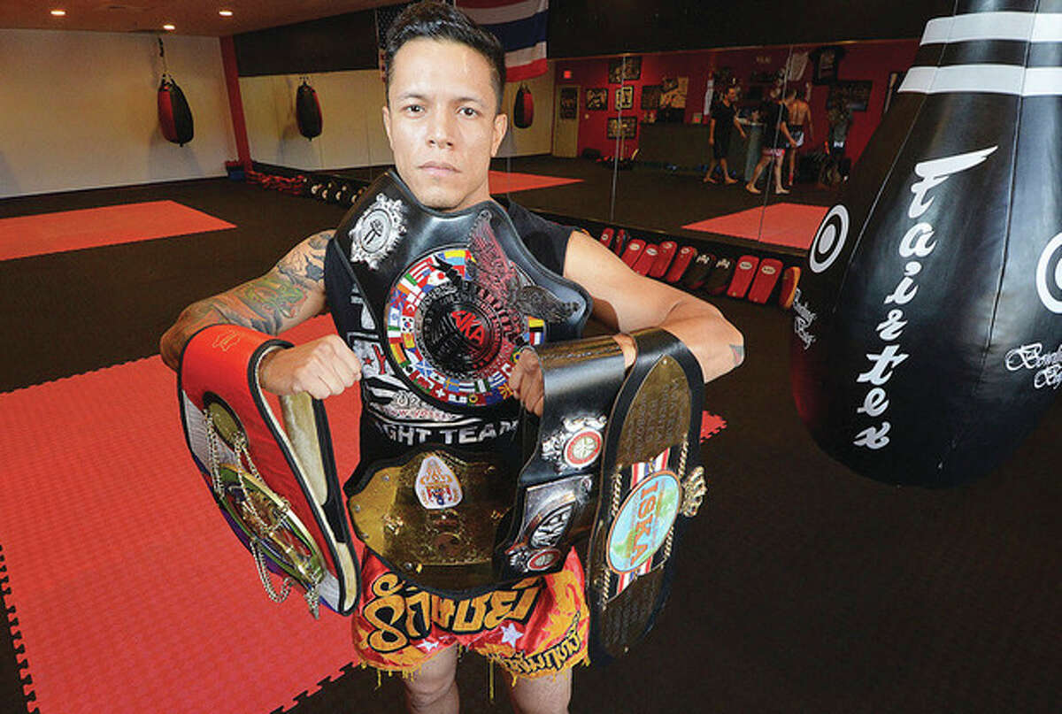Hour photo/Alex von Kleydorff Eddie Martinez holds some of the championship belts he has earned in for Muy Thai kickboxing in his Sitan Gym in Norwalk. Martinez won the New York state championship last month.