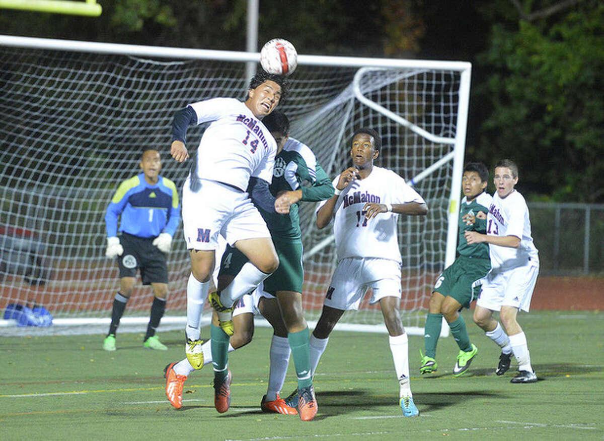 Hour photo/Alex von Kleydorff Brien McMahon's Sergio Ceja (14) heads the ball away from the goal and Norwalk's Loizos Karaiskos during some close action in front of the Senators' goal during Friday night's game at Casagrande Field. Michael Jean-Charles (17) of the Senators gets a close-up look at the play. Norwalk won the crosstown clash, 1-0.