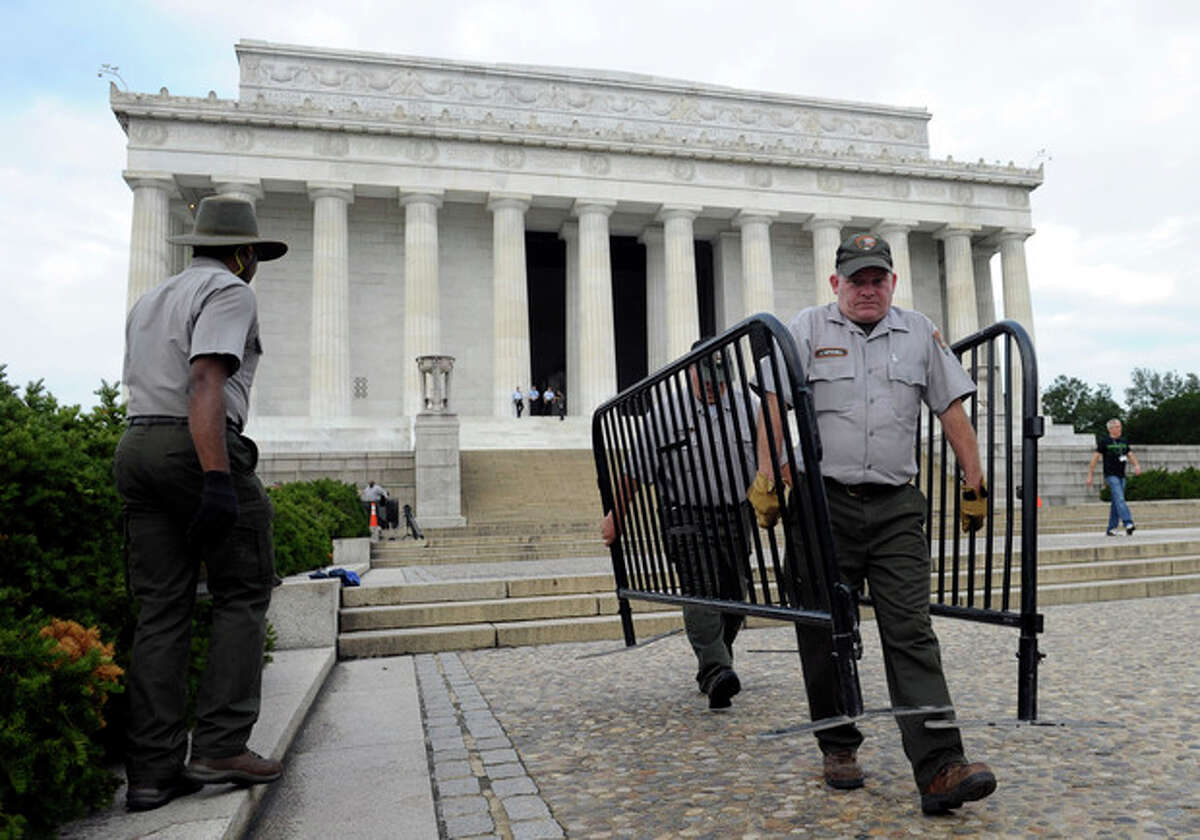 National Park Service employee James Mitchell, right, and others, remove barricades from the grounds of the Lincoln Memorial in Washington, Thursday, Oct. 17, 2013. Barriers went down at National Park Service sites and thousands of furloughed federal workers began returning to work throughout the country Thursday after 16 days off the job because of the partial government shutdown.(AP Photo/Susan Walsh)