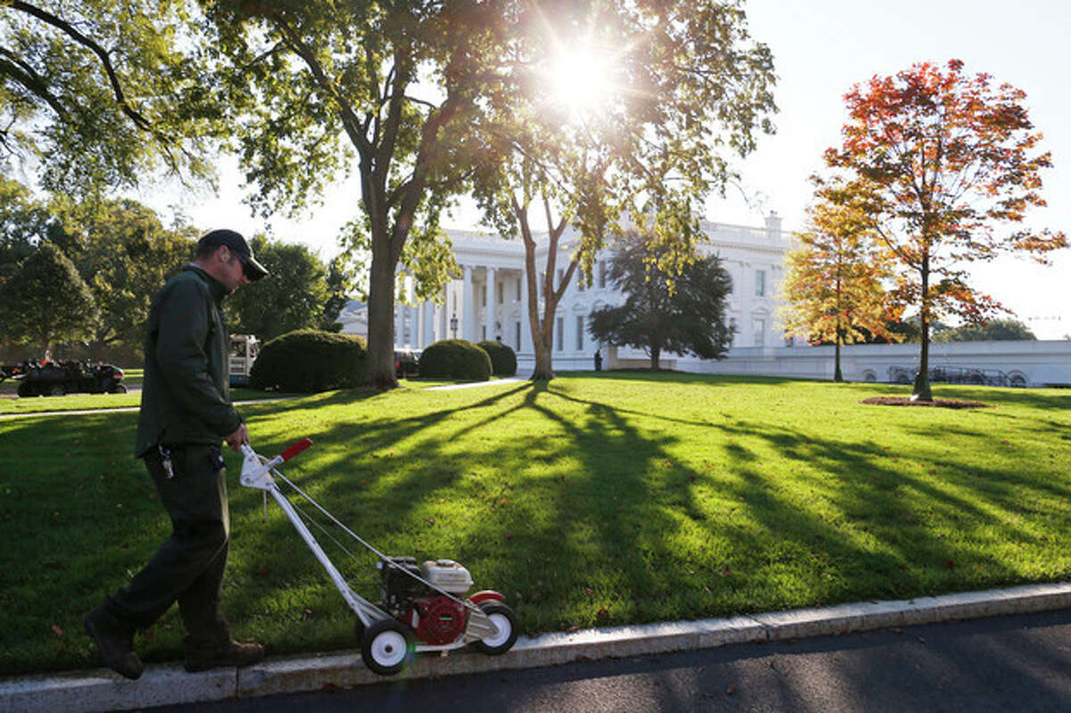 A National Park Service employee uses an edge trimmer as workers tend to the North Lawn of the White House in Washington, Friday, Oct. 18, 2013, after a 16-day partial government shutdown was resolved by lawmakers late Wednesday. (AP Photo/Charles Dharapak)