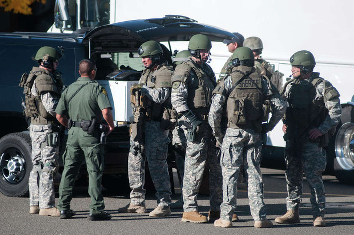 Swat team members secure the scene near Sparks Middle School in Sparks, Nev., after a shooting there on Monday, Oct. 21, 2013. Authorities are reporting that two people were killed and two wounded at the Nevada middle school. (AP Photo/Kevin Clifford)