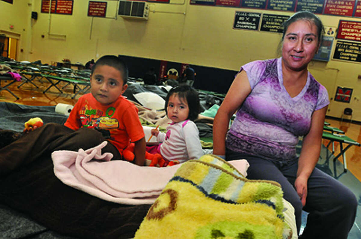 Maria DeJesus and her children, Diego 4 and Casey 2, are set up for the overnight stay at Brien McMahon high school Monday. The Red Cross has the gym available as a shelter from hurrican Sandy. hour photo/Matthew Vinci