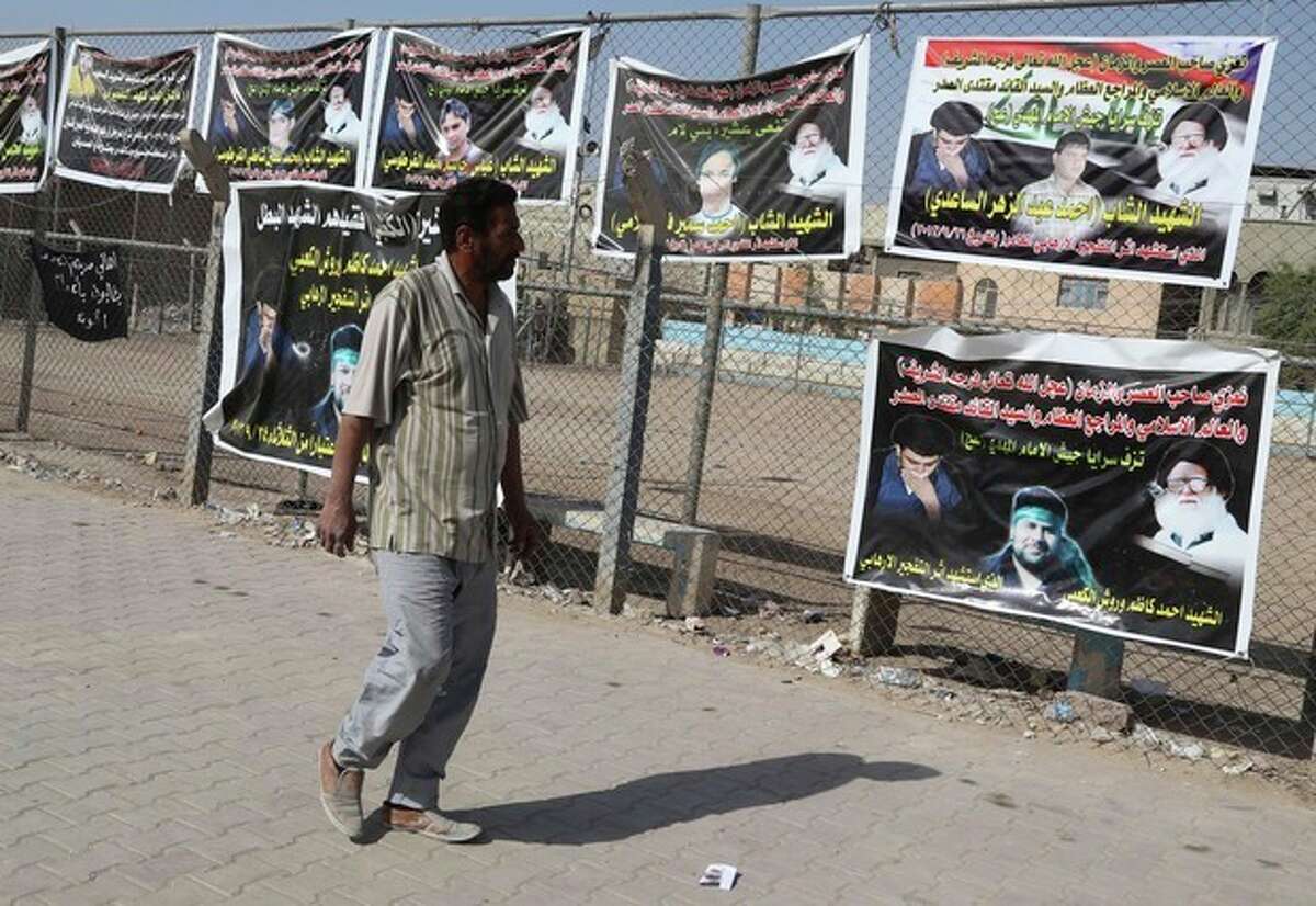 In this photo taken Friday, Oct. 25, 2013, a man walks past posters of Shiite people who were killed during recent attacks in Sadr city in Baghdad, Iraq. The wave of attacks by al-Qaida and Sunni extremists that has killed thousands of Iraqis in 2013 so far, most of them Shiites, is provoking ominous calls from Shiite leaders to take up arms in self-defense. Iraqs Shiite prime minister, Nouri al-Maliki, who will meet with U.S. President Barack Obama on Friday, Nov. 1, 2013, said he wants American help in quelling the violence. (AP Photo/Karim Kadim)