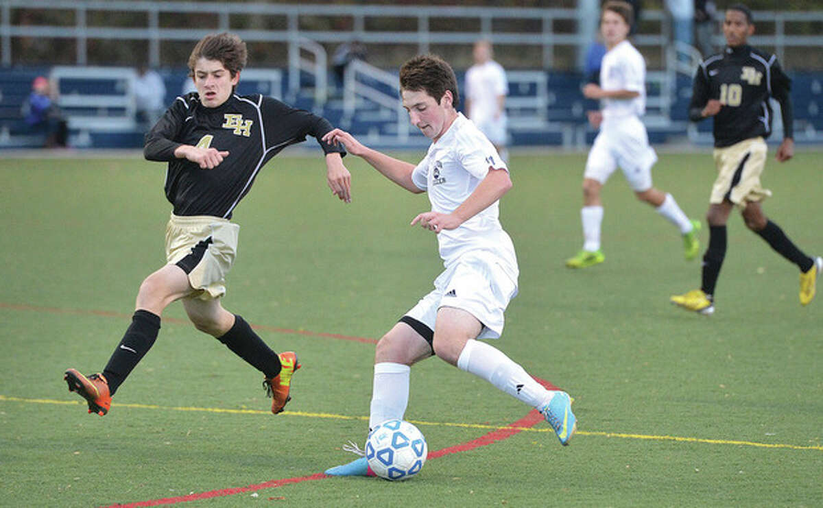 Hour photo/Alex von Kleydorff Wilton's Justin Shepard, right, lines up the ball as an East Hartford defender closes in during Tuesday's state tournament game in Wilton. The Warriors moved on after claiming a 1-0 victory.