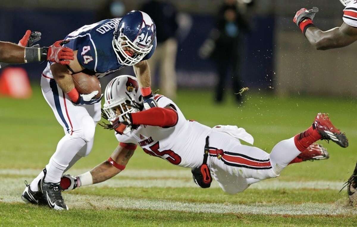 Louisville safety Calvin Pryor, right, dives as he tries to tackle Connecticut running back Max DeLorenzo (44) during the first half of an NCAA college football game, in East Hartford, Conn., Friday, Nov. 8, 2013. (AP Photo/Charles Krupa)