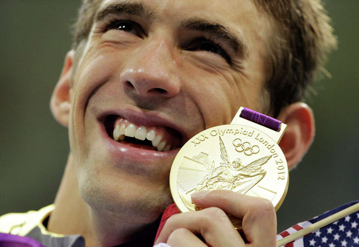 FILE - United States' Michael Phelps poses with his gold medal for the men's 4x200-meter freestyle relay swimming final at the Aquatics Centre in the Olympic Park during the 2012 Summer Olympics in London, in this July 31, 2012 file photo. Michael Phelps has rejoined the U.S. drug testing program, the strongest signal yet that he's planning a comeback for the Rio Olympics. Phelps told The Associated Press on Thursday Nov. 14, 2013 that "nothing is set in stone" though clearly he has enjoyed getting back into shape _ he's down about 15 pounds _ and working out with his former team at the North Baltimore Aquatic Club. (AP Photo/Matt Slocum, File)