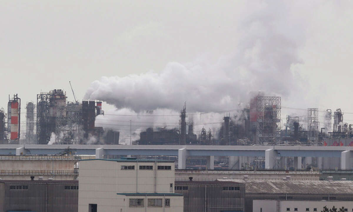 In this Monday, Oct. 21, 2013 photo, smoke billows from an oil refinery in Kawasaki, southwest of Tokyo. Japan has drastically scaled back its target for reducing greenhouse gas emissions, complicating efforts to forge a global climate change pact.The new target approved by the Cabinet on Friday, Nov 15 calls for reducing emissions by 3.8 percent from their 2005 level by 2020. The revision was necessary because the earlier goal of a 25 percent reduction from the 1990 level was unrealistic, the chief government spokesman, Yoshihide Suga, told reporters in Tokyo. (AP Photo/Koji Sasahara)