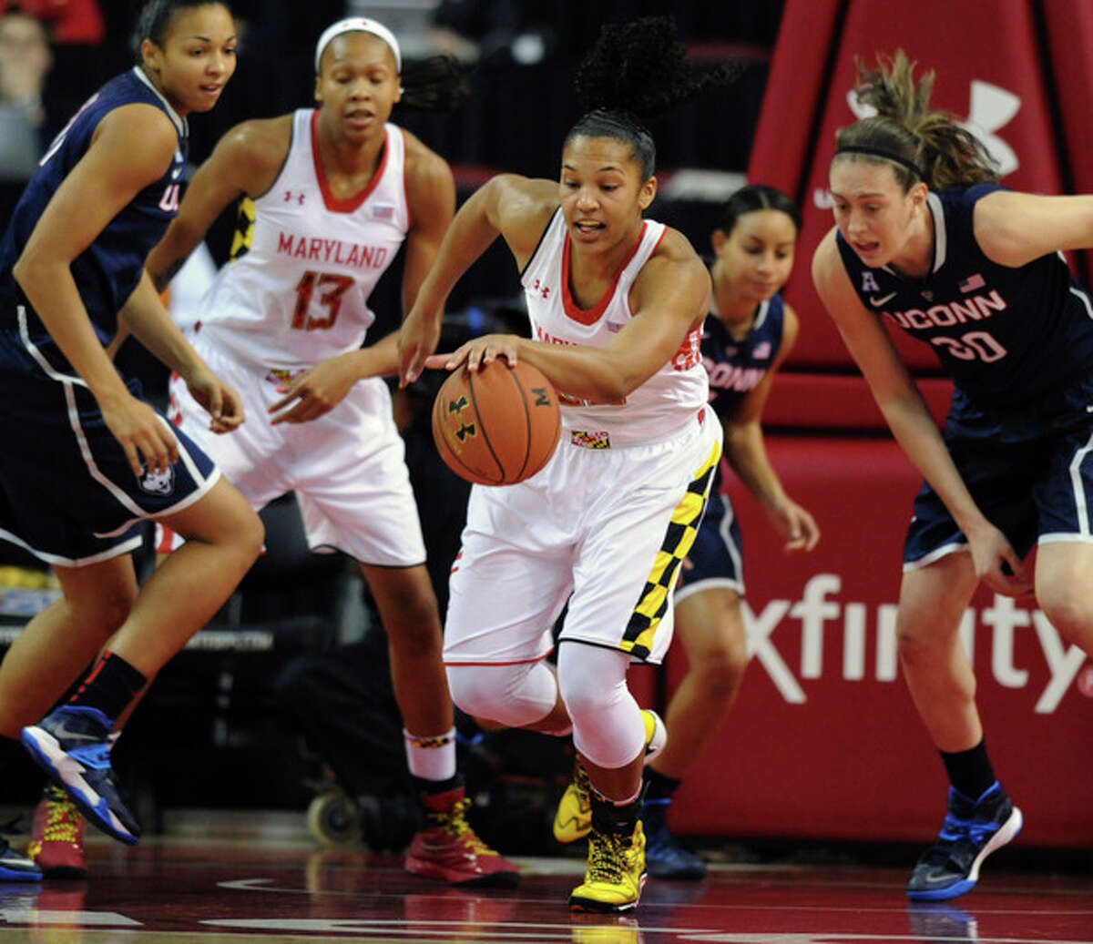 Maryland's Alyssa Thomas, center, grabs a rebound ahead of Connecticut's Breanna Stewart, right, in the first half of an NCAA basketball game Friday, Nov. 15, 2013 in College Park, Md.(AP Photo/Gail Burton)