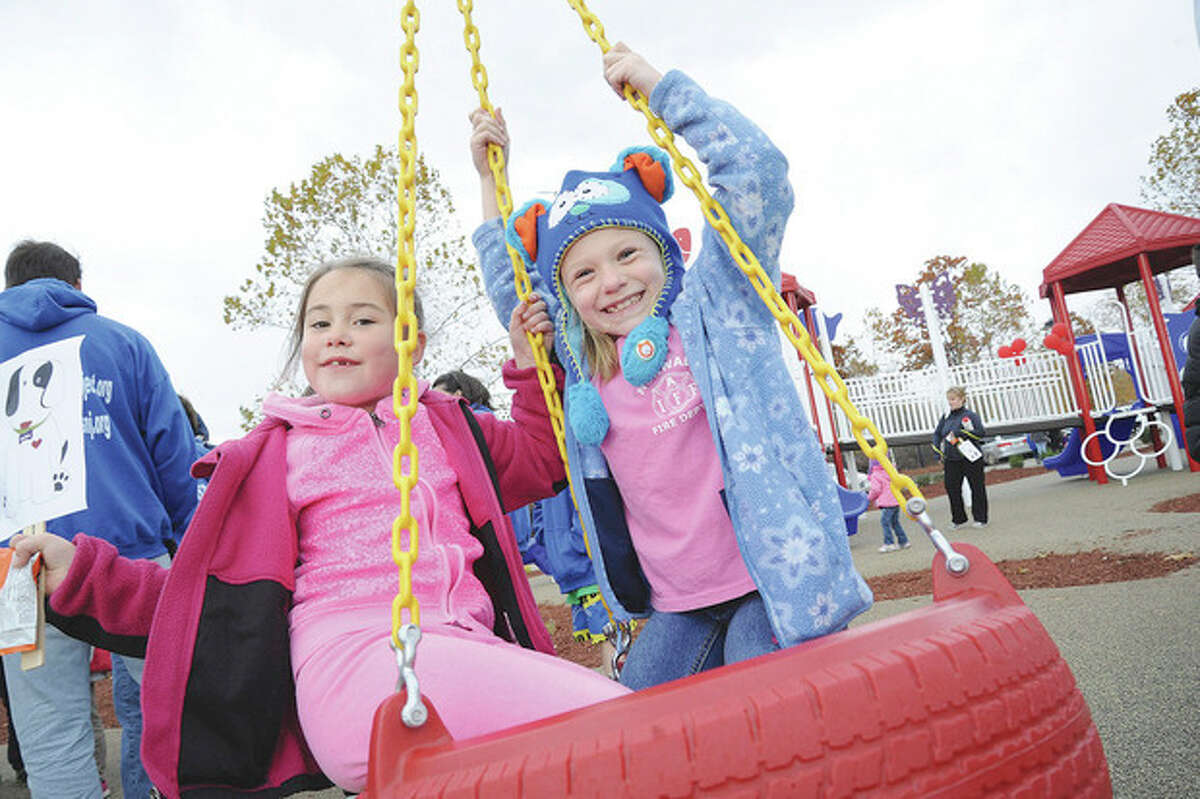 Hour photo / Matthew Vinci Riley Alesevich, 6, and Lindsey Rywolt, 7, swing on a tire at the new playground that opened at Oyster Shell Park to celebrate the life of Allison Wyatt, a student who died in the Newtown shooting at Sandy Hook Elementary School.