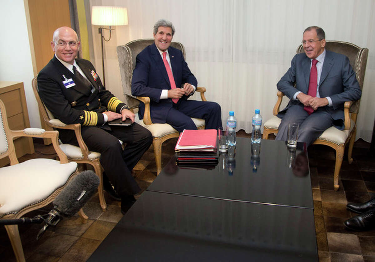From left, Vice Admiral Kurt Tidd, U.S. Secretary of State John Kerry and Russia's Foreign Minister Sergei Lavrov look to a boom microphone held by a member of the media, lower left corner, as they sit together during a photo opportunity during a meeting, Saturday, Nov. 23, 2013, in Geneva, Switzerland, during the Iran nuclear talks. U.S. Secretary of State John Kerry and foreign ministers of other major powers joined Iran nuclear talks on Saturday, throwing their weight behind a diplomatic push to complete a deal after envoys reported progress on key issues blocking an interim agreement to curb the Iranian program in return for limited sanctions relief. (AP Photo/Carolyn Kaster, Pool)
