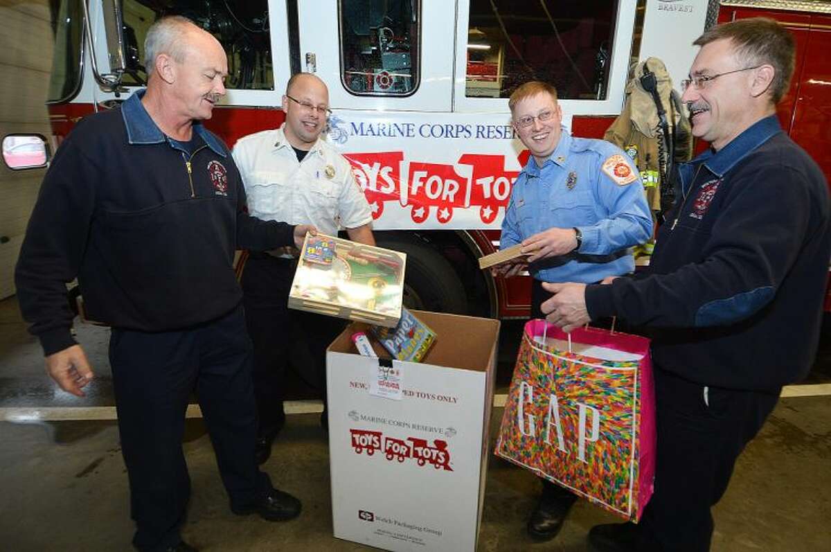 Hour Photo/Alex von Kleydorff. Ralph Nathanson, Kevin Czarnecki, Brian Elliott and Gary Fuoco are part of the Wilton Firefighters drive to collect toys for the Toys for Tots program.