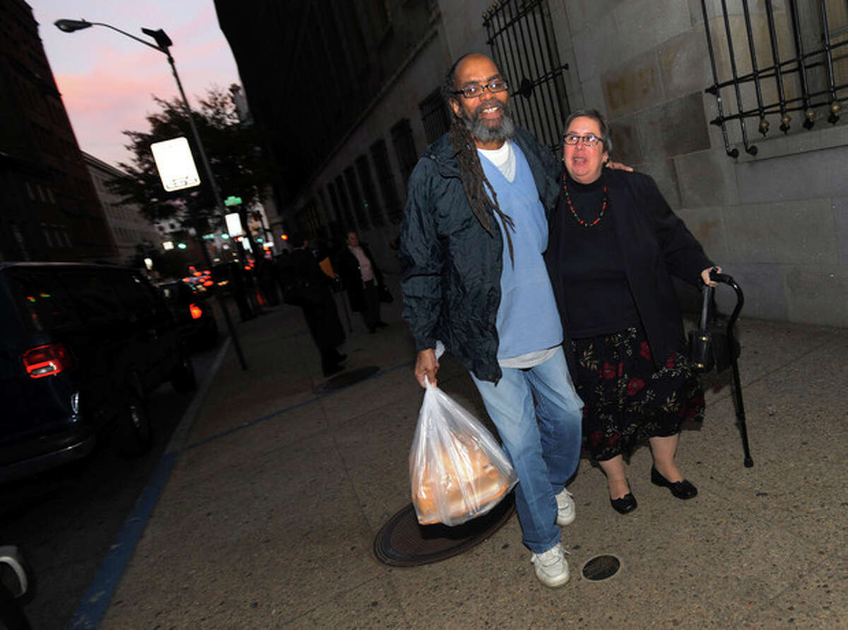 In this photo taken on Thursday, Nov. 14, 2013, freed prisoner Salim Sadiki, who served 37 years after being found guilty of rape, walks away from the courthouse in Baltimore with a friend after being released from prison. Faulty jury instructions given at trials held decades ago have led prosecutors in Maryland to release approximately 50 people, and some 200 prisoners could ultimately be released from Maryland prisons as a result. (AP Photo/Gail Burton)