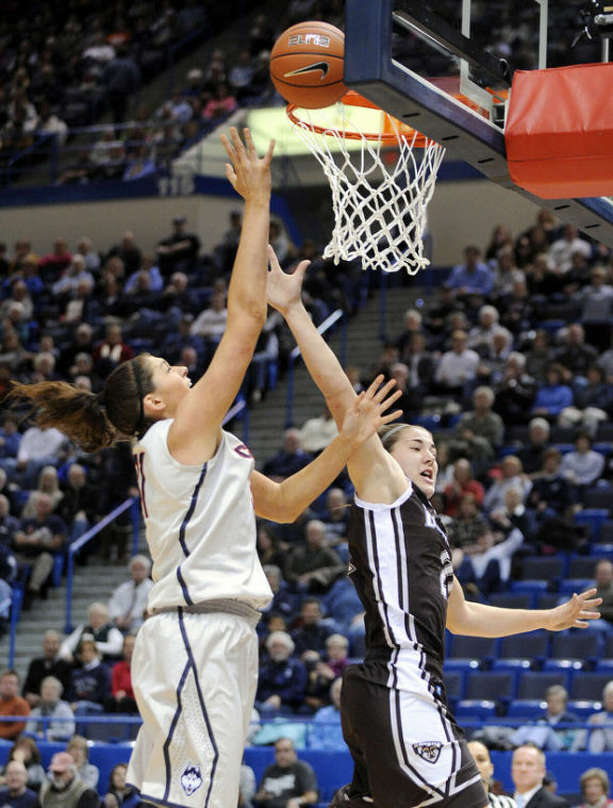 Connecticut's Stefanie Dolson, left, shoots over St. Bonaventure's Nyla Rueter during the first half of an NCAA college basketball game in Hartford, Conn., on Sunday, Nov. 24, 2013. (AP Photo/Fred Beckham)