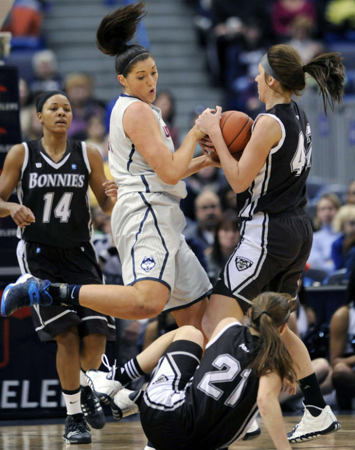 Connecticut's Stefanie Dolson, second from left, fights for a rebound with St. Bonaventure's Katie Healy, right, as St. Bonaventure's Nyla Rueter (21) and Gabby Richmond (14) stand by during the first half of an NCAA college basketball game in Hartford, Conn., on Sunday, Nov. 24, 2013. (AP Photo/Fred Beckham)