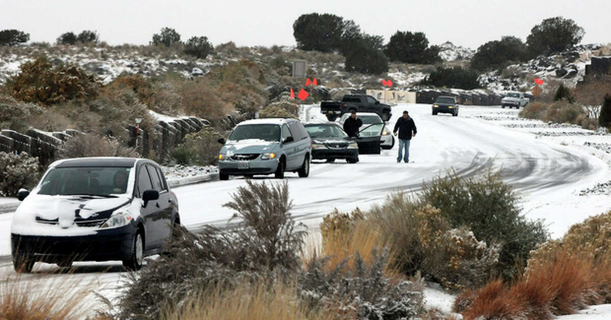 Cars slide on Paseo del Norte Sunday, Nov.24, 2013, in Albuquerque, N.M., after a winter storm hit New Mexico over the weekend making driving difficult for drivers. A large storm already blamed for at least eight deaths in the West slogged through Oklahoma, Texas, New Mexico and other parts of the southwest Sunday as it slowly churned east ahead of Thanksgiving.(AP PhotosAlbuquerque Journal, Jim Thompson) THE SANTA FE NEW MEXICAN OUT