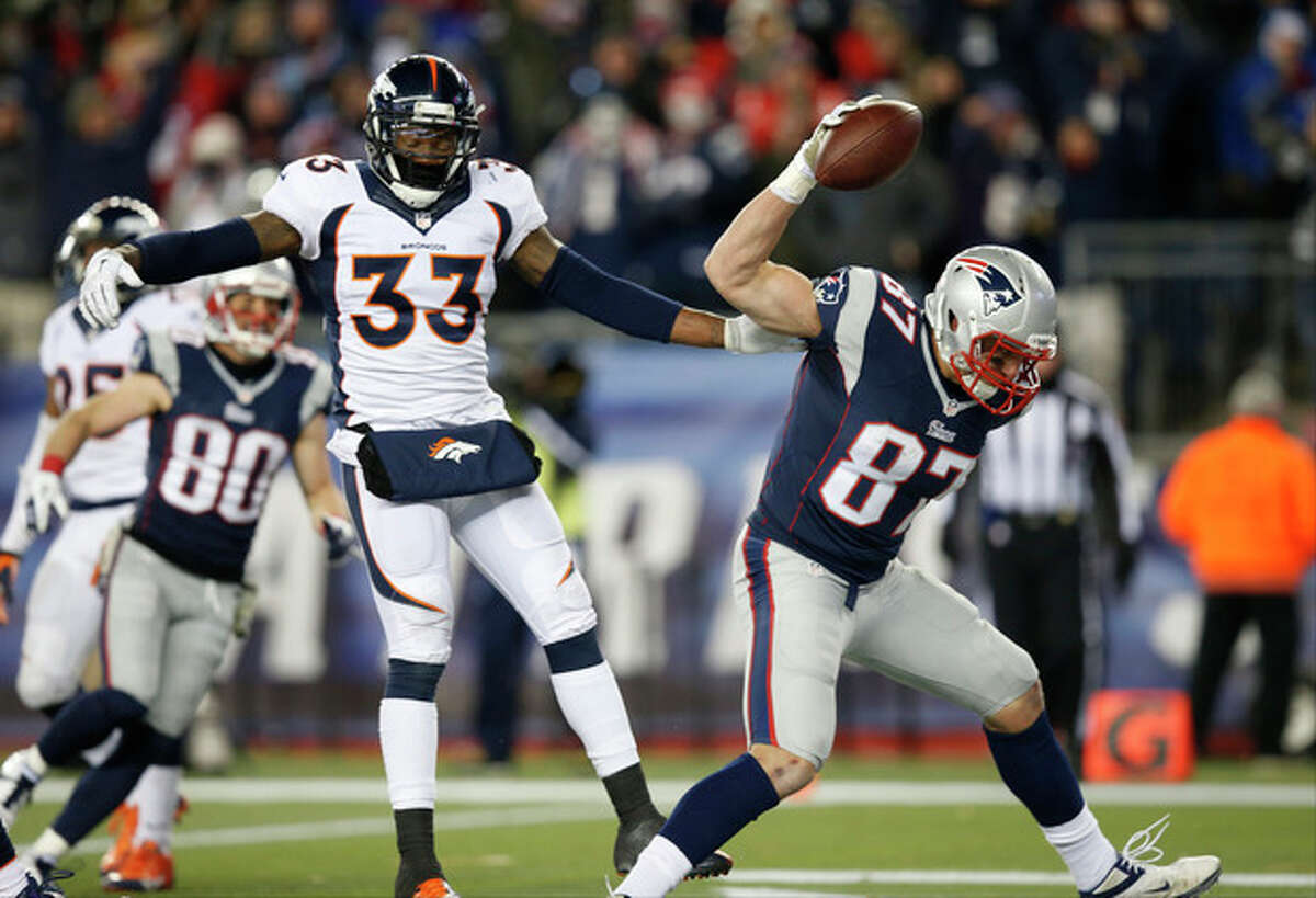 New England Patriots tight end Rob Gronkowski (87) celebrates his touchdown in front of Denver Broncos safety Duke Ihenacho (33) in the third quarter of an NFL football game Sunday, Nov. 24, 2013, in Foxborough, Mass. (AP Photo/Elise Amendola)