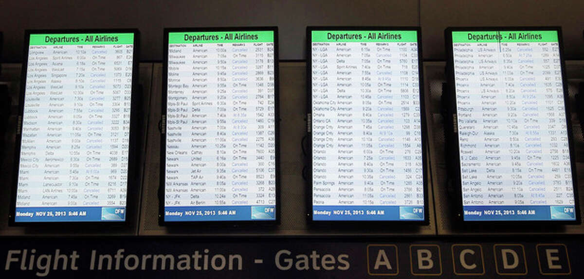 Departure boards display dozens of canceled flights in terminal D at Dallas-Fort Worth International airport, Monday, Nov. 25, 2013. Winter weather has caused travel disruptions throughout the area. (AP Photo/Brandon Wade)