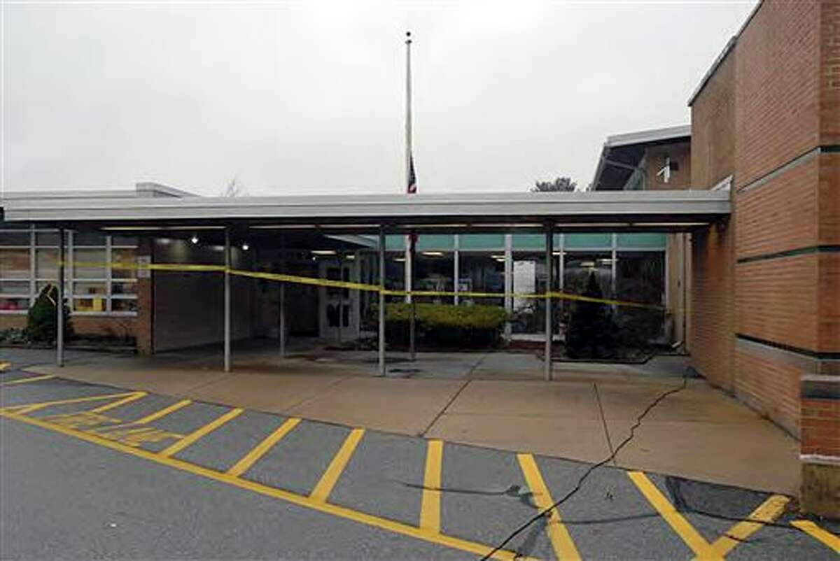 This image contained in the "Appendix to Report on the Shootings at Sandy Hook Elementary School and 36 Yogananda St., Newtown, Connecticut On December 14, 2012" and released Monday, Nov. 25, 2013, by the Danbury, Conn., State’s Attorney shows a scene outside the entrance to Sandy Hook Elementary School in Newtown, Conn. Adam Lanza opened fire inside the school killing 20 first-graders and six educators before killing himself as police arrived. (AP Photo/Office of the Connecticut State's Attorney Judicial District of Danbury)