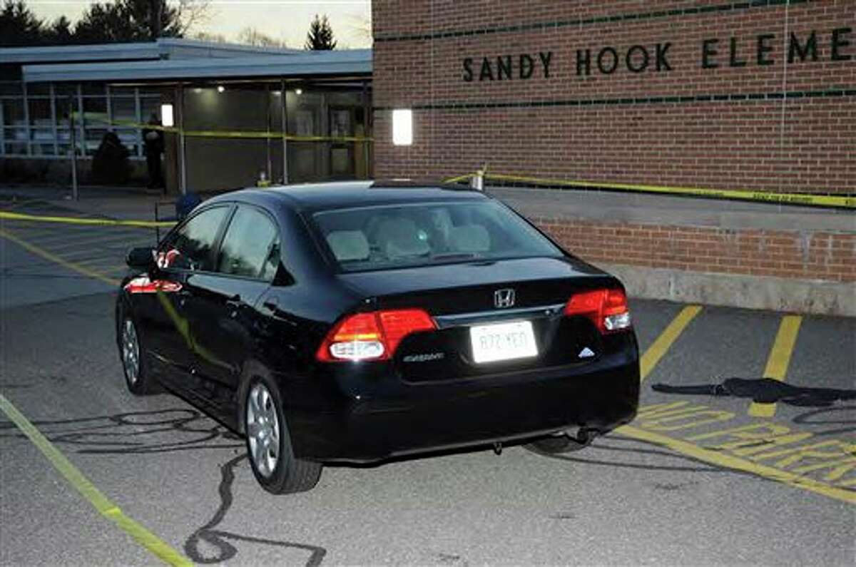 This image contained in the "Appendix to Report on the Shootings at Sandy Hook Elementary School and 36 Yogananda St., Newtown, Connecticut On December 14, 2012" and released Monday, Nov. 25, 2013, by the Danbury, Conn., State’s Attorney shows a vehicle outside Sandy Hook Elementary School in Newtown, Conn. Adam Lanza opened fire inside the school killing 20 first-graders and six educators before killing himself as police arrived. (AP Photo/Office of the Connecticut State's Attorney Judicial District of Danbury)