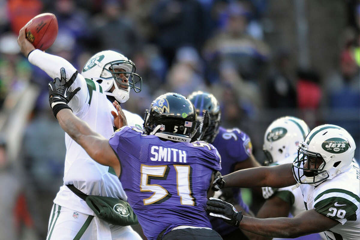 New York Jets quarterback Geno Smith, left, passes the ball under pressure from Baltimore Ravens inside linebacker Daryl Smith (51) during the first half of an NFL football game in Baltimore, Md., Sunday, Nov. 24, 2013. (AP Photo/Gail Burton)