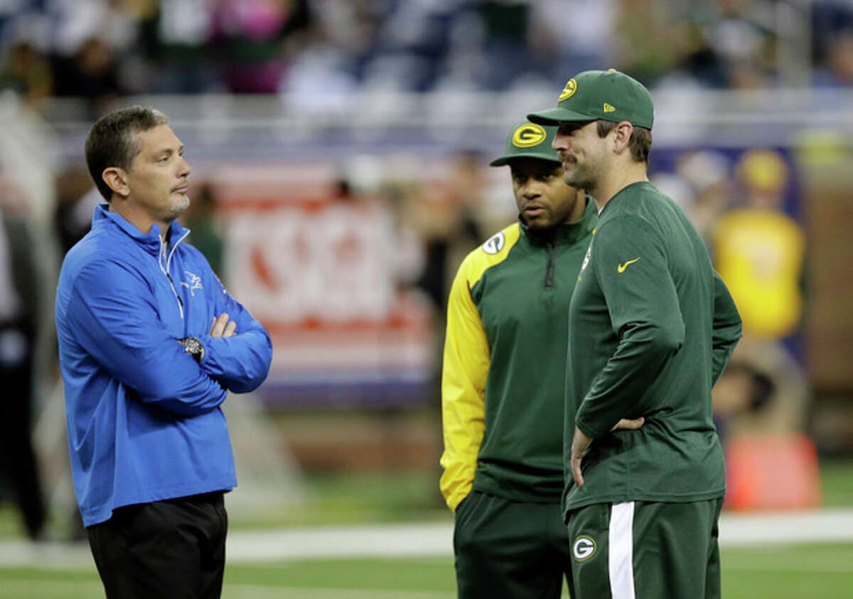 Detroit Lions head coach Jim Schwartz talks with Green Bay Packers wide receiver Randall Cobb, center, and quarterback Aaron Rodgers during a warm up period before an NFL football game at Ford Field in Detroit, Thursday, Nov. 28, 2013. (AP Photo/Carlos Osorio)