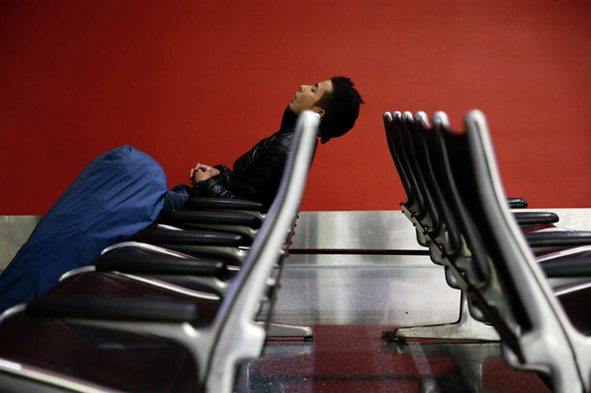 A man sleeps at the Los Angeles International Airport on Wednesday, Nov. 27, 2013, in Los Angeles. More than 43 million people are to travel over the long holiday weekend, according to AAA. (AP Photo/Jae C. Hong)