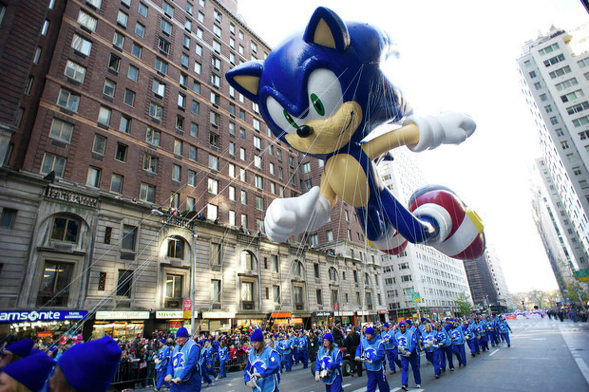 FILE - In this Nov. 22, 2012, file photo, handlers keep a tight rein on the Sonic the Hedgehog balloon as it travels the route of the Macy's Thanksgiving Day Parade in New York. Macy?’s says it is closely monitoring the weather after recent forecasts predicted wind gusts up to 30 mph on Thanksgiving morning during the department store?’s upcoming Thanksgiving Day Parade. Based on New York City guidelines, no giant balloons will be operated if the wind gusts exceed 34 mph. (AP Photo/Charles Sykes, File)