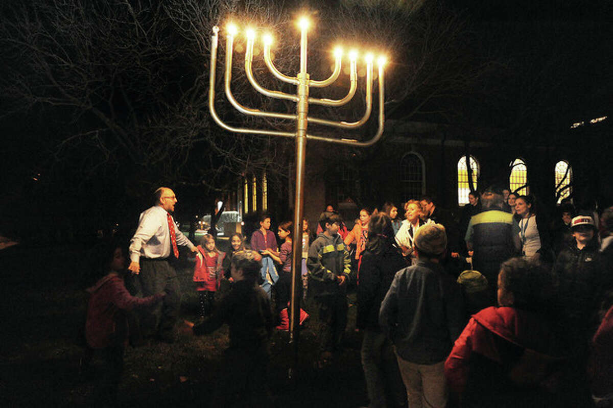 Rabbi Fish of Congregation Beth El leads a Hanukah lighting with children from Beth El's Nevasky Hebrew School on Tuesday night. Hour photo/Matthew Vinci