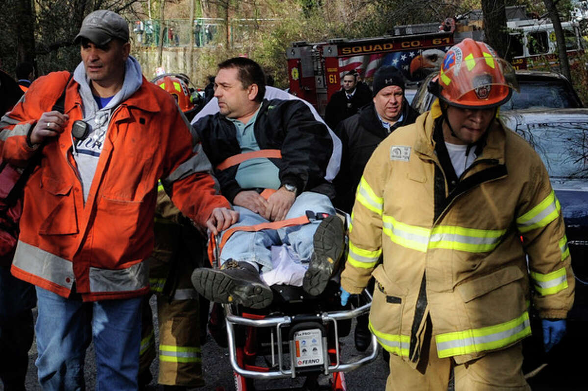 FILE - In this file photo taken on Sunday, Dec. 1, 2013, Metro North Railroad engineer William Rockefeller is wheeled on a stretcher away from the area where the commuter train he was operating derailed in the Bronx borough of New York. The engineer driving the commuter train that went off the rails in New York City last weekend has been suspended without pay according to a spokesman for Metro-North Railroad Thursday Dec. 5, 2013. (AP Photo/Robert Stolarik, File)
